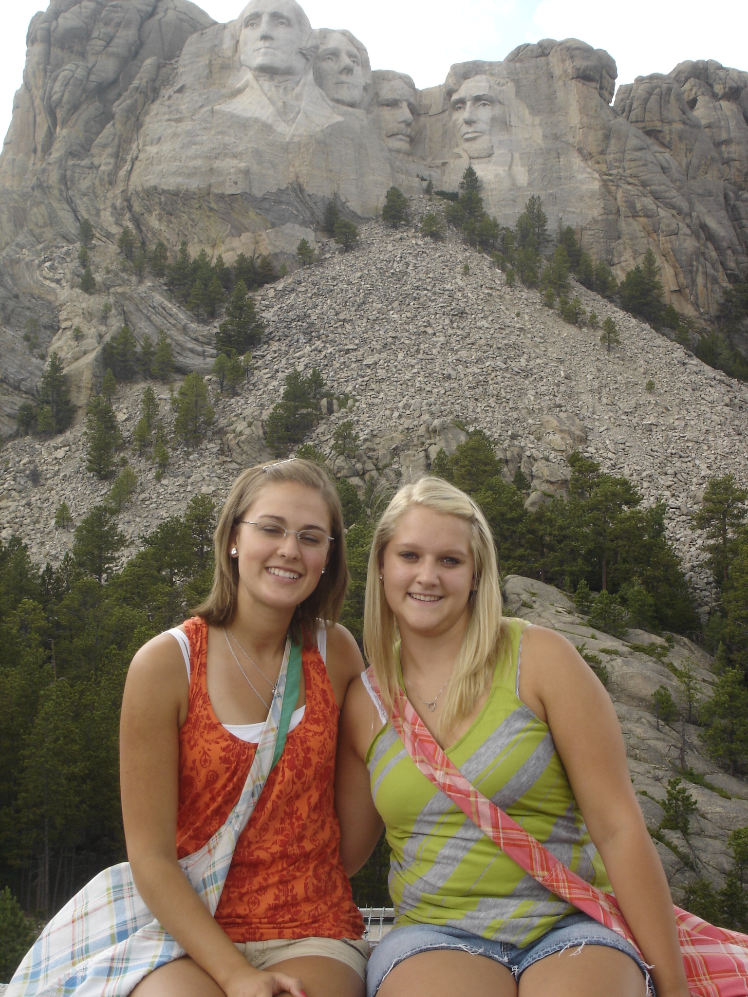 Courtney and Jenna sitting in front of Mt. Rushmore